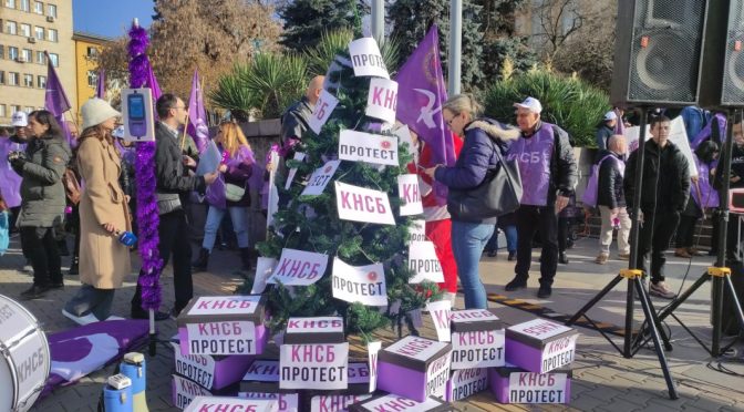 Коледна елха, но с празни кутии под нея, на жълтите павета в центъра на София